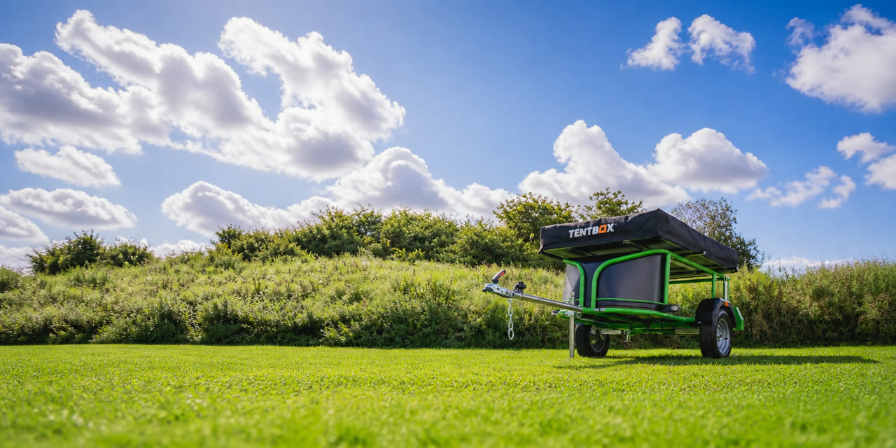 Nomad Micro trailer with TentBox on grass under a blue sky