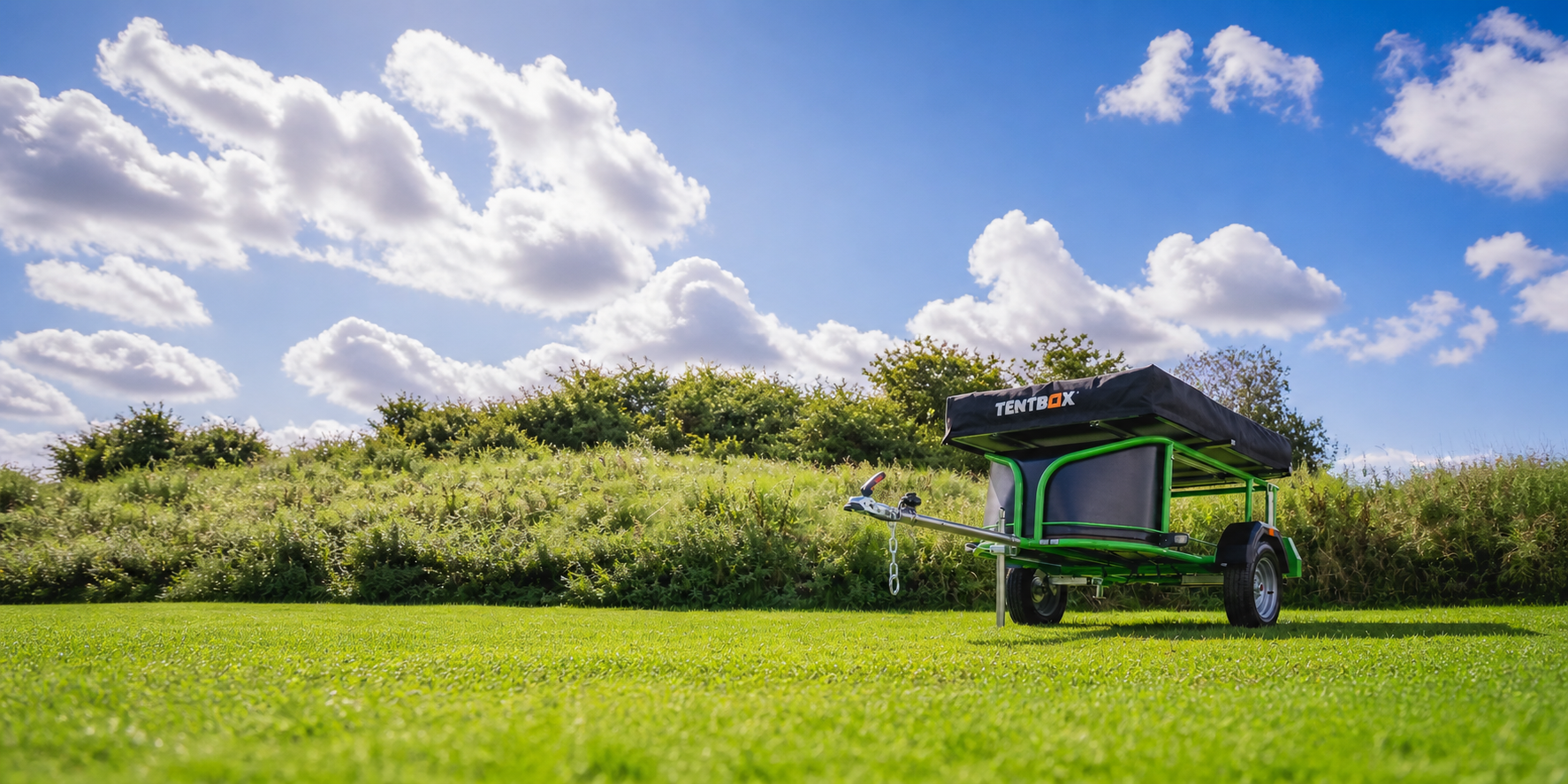 Nomad Micro trailer with TentBox on grass under a blue sky